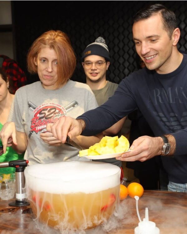 Vibrant scene of The J.chefé In-person Cocktail Experience, featuring participants crafting and enjoying artisanal cocktails in a social setting.